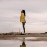 a woman standing and reflecting on life at beach