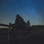 young people gazing at stars at night
