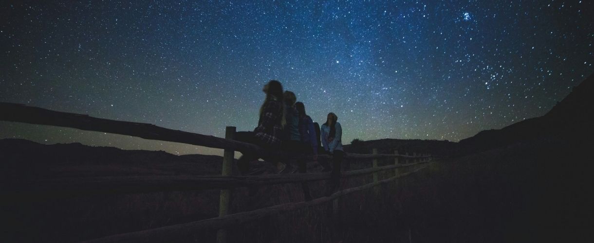 young people gazing at stars at night